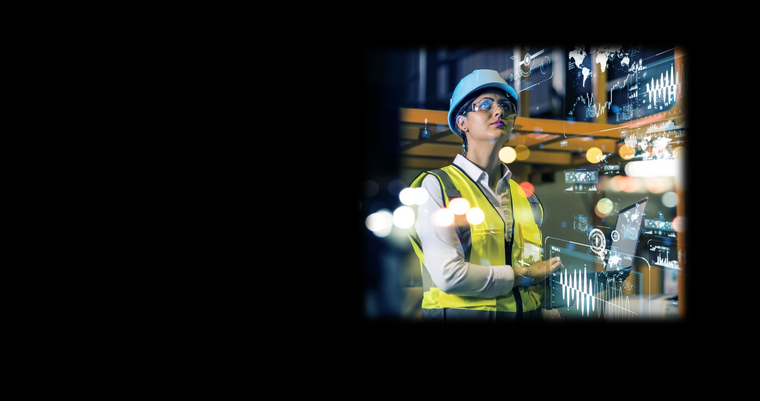 Woman in hard hat on computer in factory