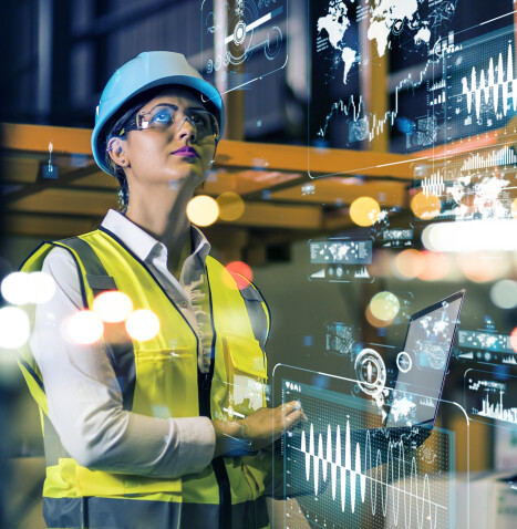 Female in protective gear holding a laptop